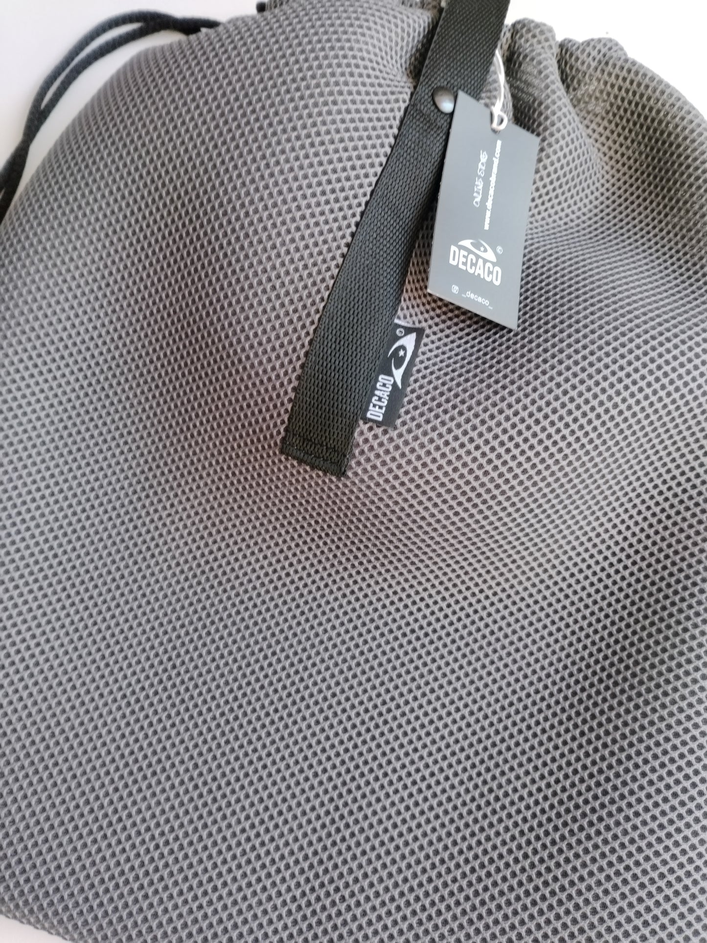 Bolso deportivo gris de malla, perfecto para llevar tus pertenencias a la playa o la piscina.