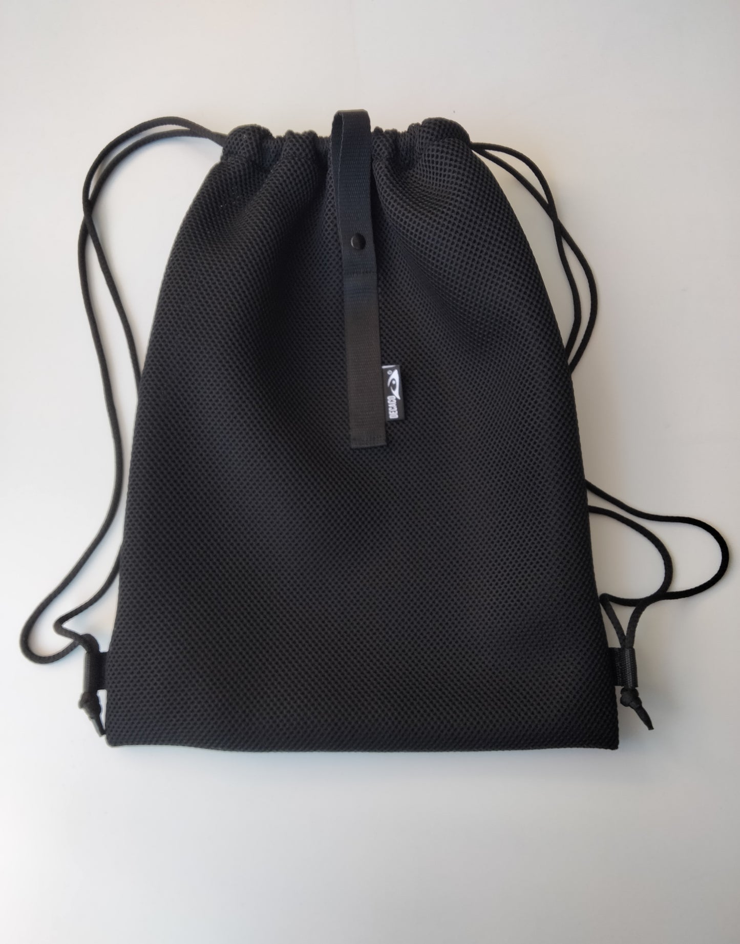 Mochila de malla en color negro, ideal para el gimnasio o actividades al aire libre. Ligera y transpirable.