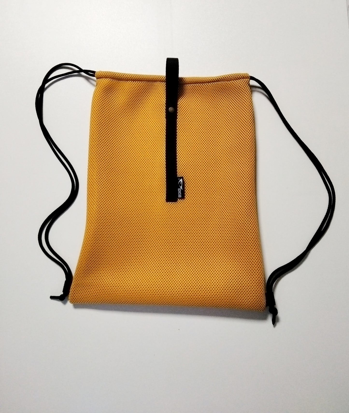 Mochila de malla en color mostaza, ideal para el gimnasio o actividades al aire libre. Ligera y transpirable.